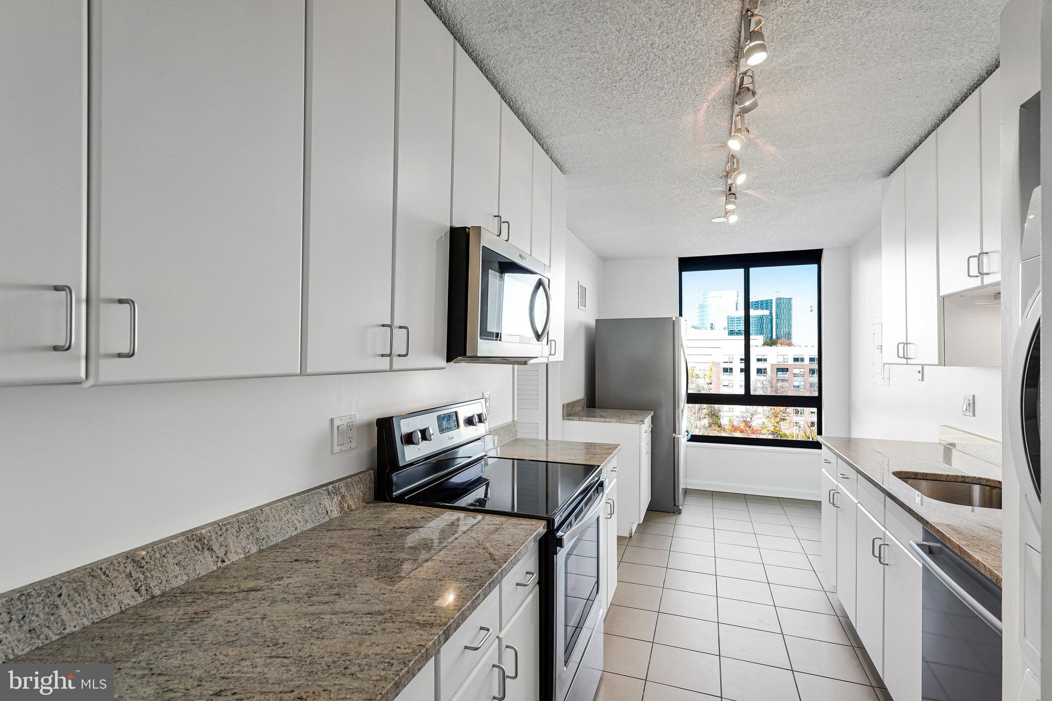 1800 Old Meadow Road, Unit 302 McLean, VA 22102 - Photo 7 of 35 a kitchen with a stove a sink and a refrigerator
