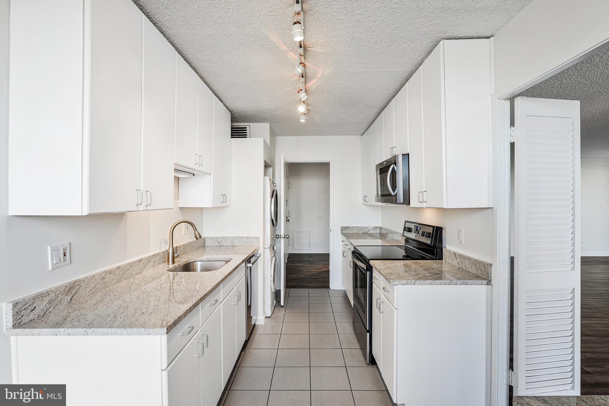 1800 Old Meadow Road, Unit 302 McLean, VA 22102 - Photo 8 of 35 a kitchen with stainless steel appliances granite countertop a sink stove and refrigerator