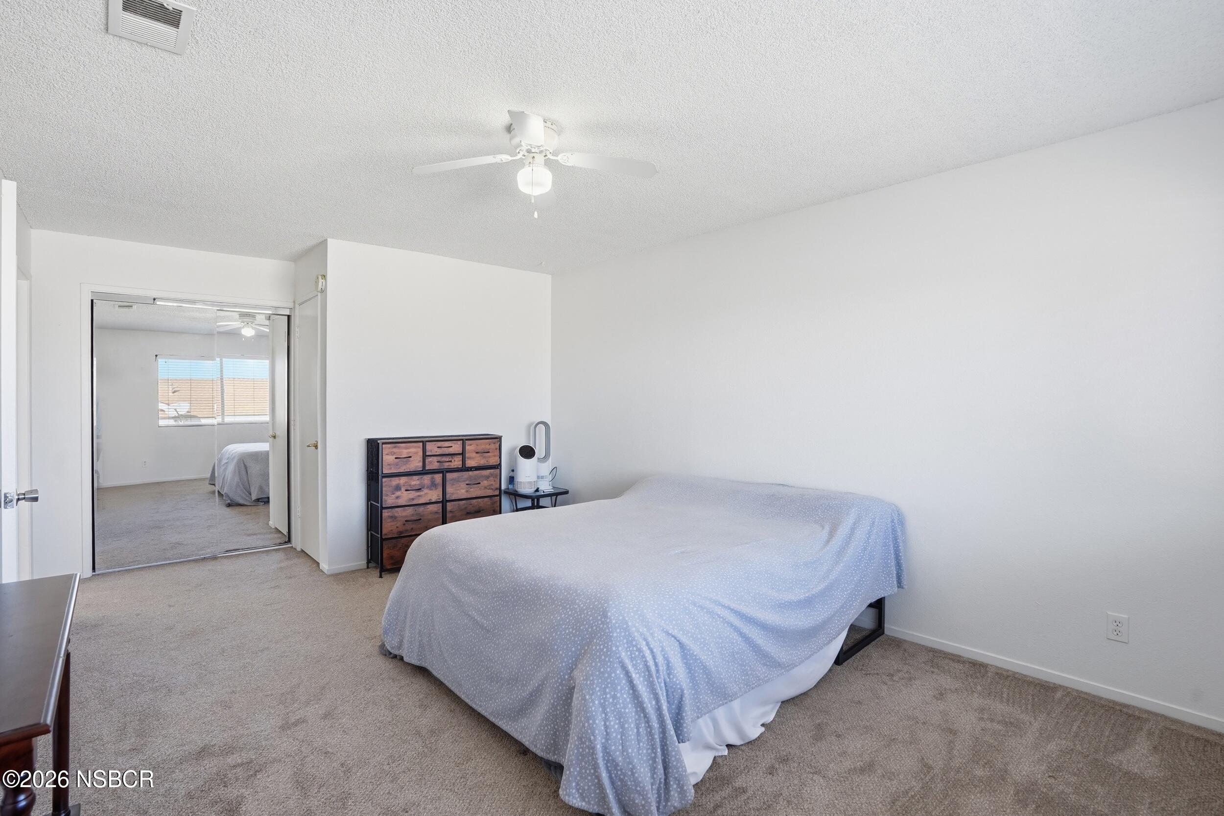 1193 East Foster Road, Unit D Santa Maria, CA 93455 - Photo 17 of 24 a bedroom with a bed and lamp