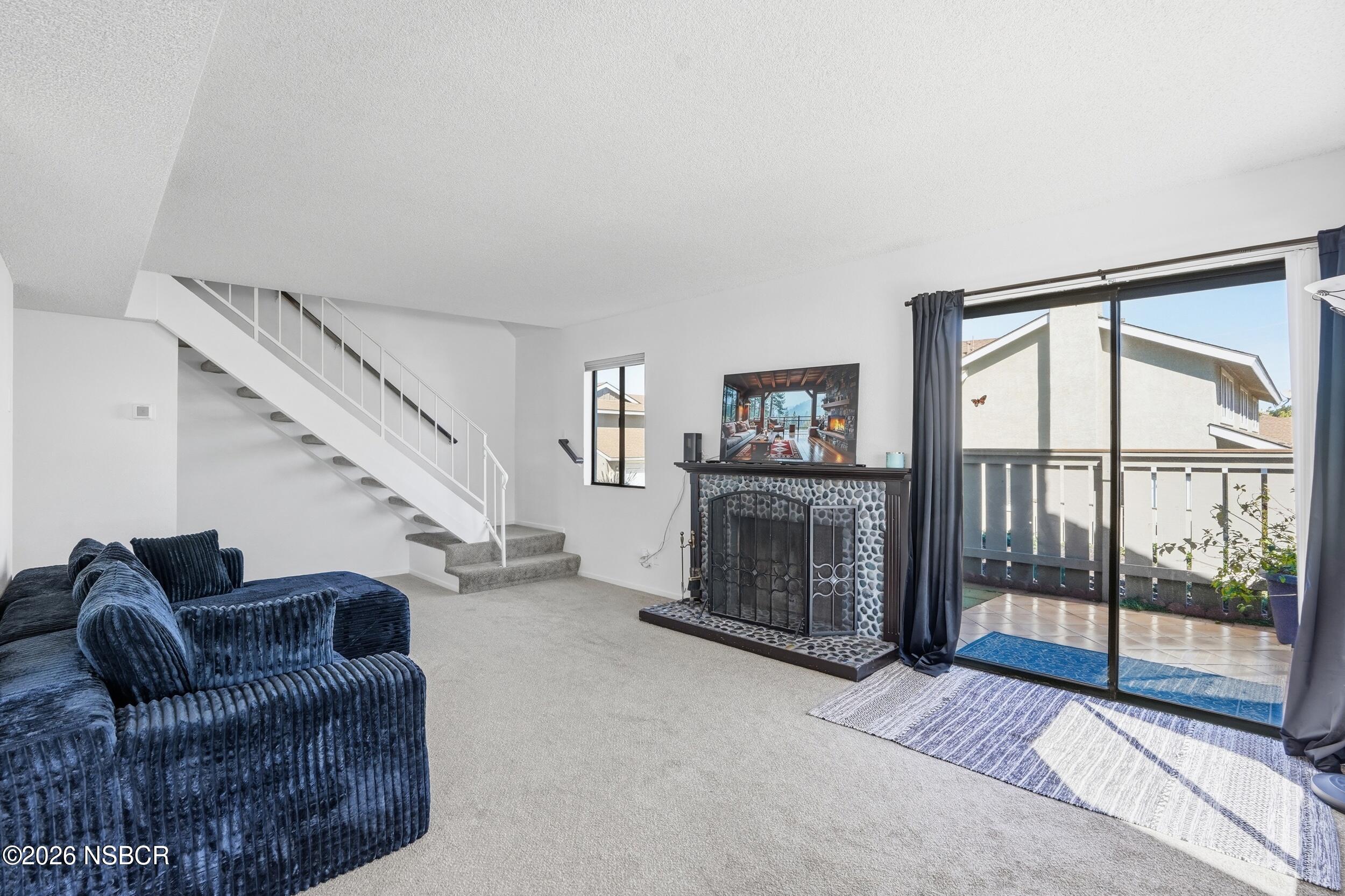 1193 East Foster Road, Unit D Santa Maria, CA 93455 - Photo 3 of 24 a living room with furniture a ceiling fan and a floor to ceiling window