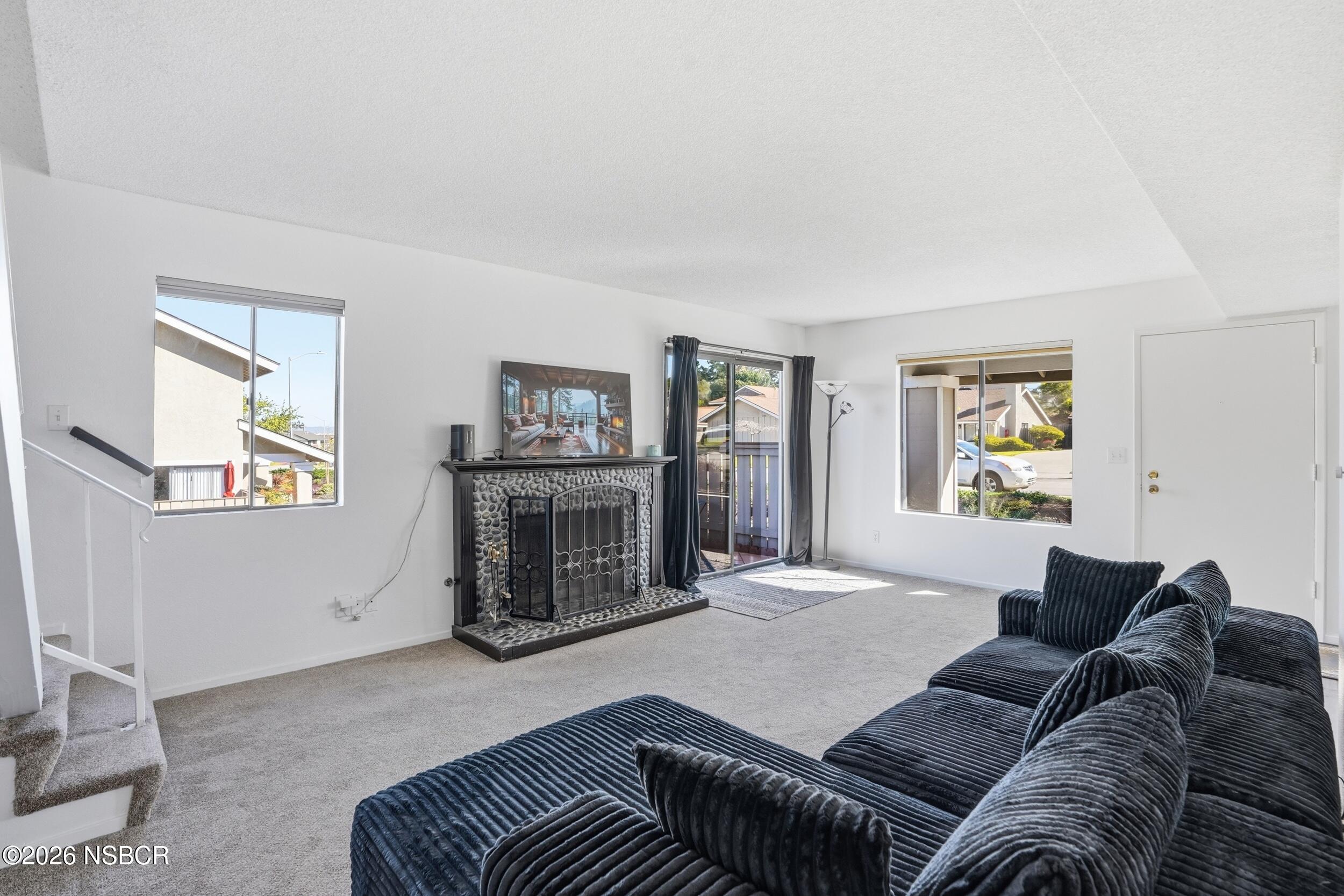 1193 East Foster Road, Unit D Santa Maria, CA 93455 - Photo 4 of 24 a living room with furniture a large window and a fireplace