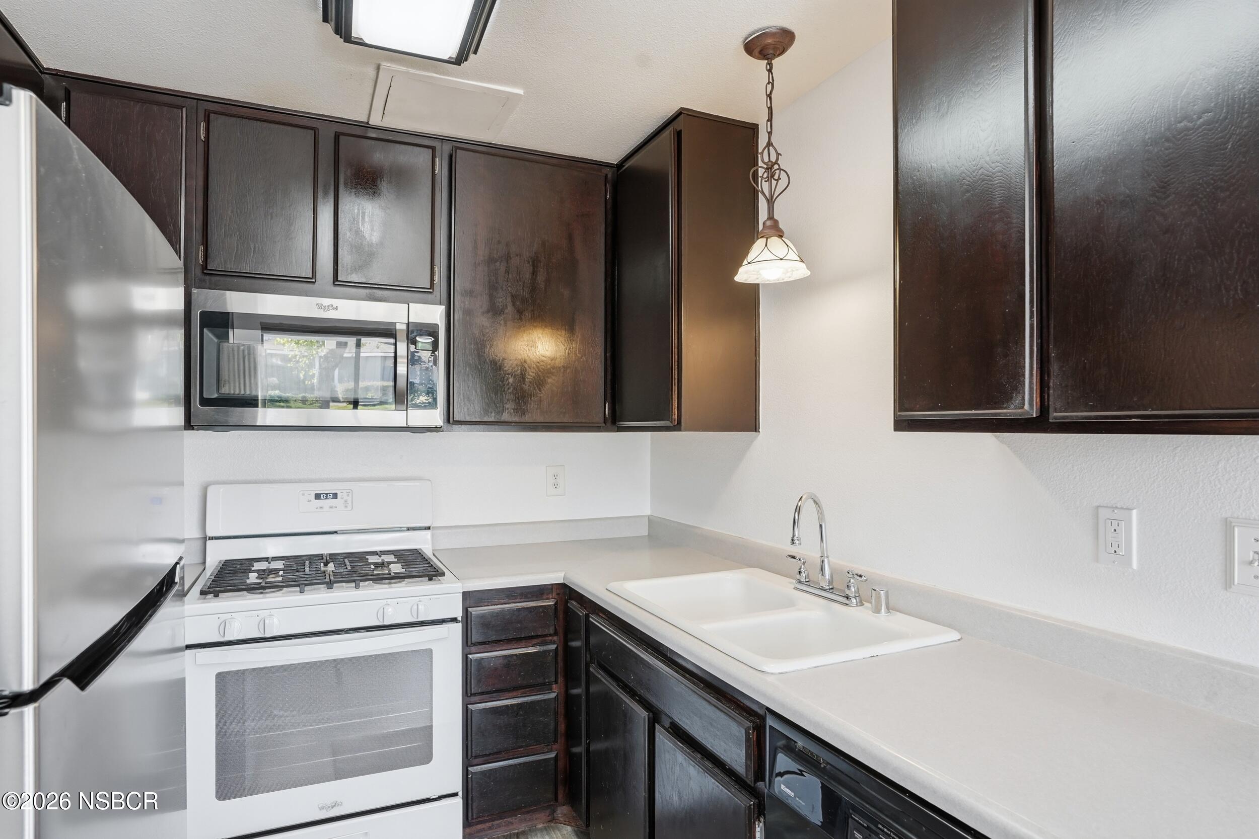 1193 East Foster Road, Unit D Santa Maria, CA 93455 - Photo 6 of 24 a kitchen with a sink cabinets and stainless steel appliances