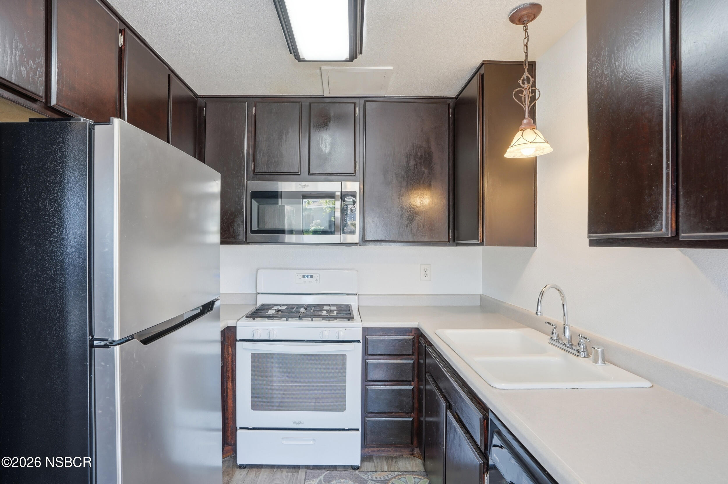 1193 East Foster Road, Unit D Santa Maria, CA 93455 - Photo 8 of 24 a kitchen with stainless steel appliances granite countertop a sink stove and refrigerator