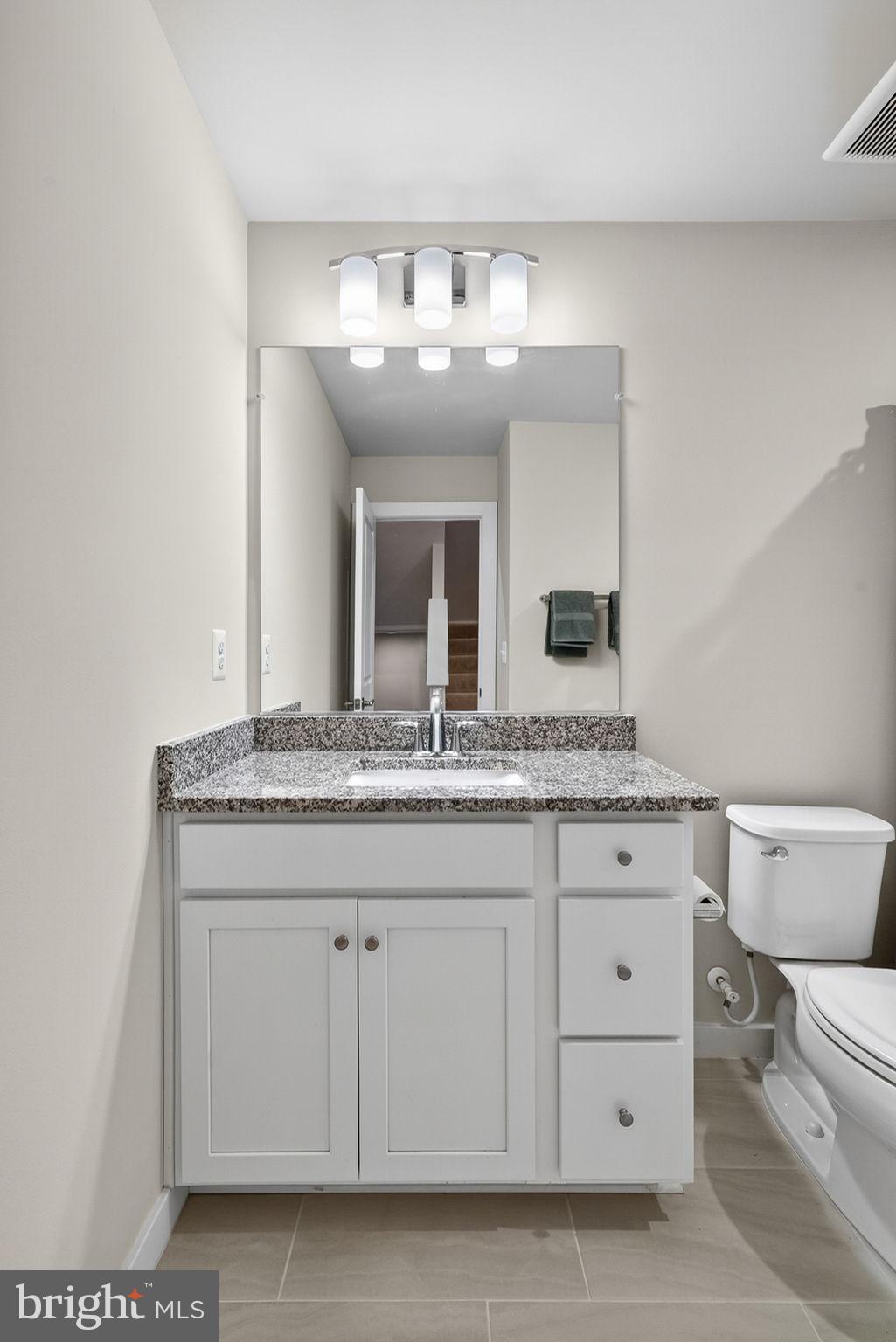 18245 Moss Garden Road Dumfries, VA 22026 - Photo 22 of 71 a bathroom with a granite countertop sink and a mirror