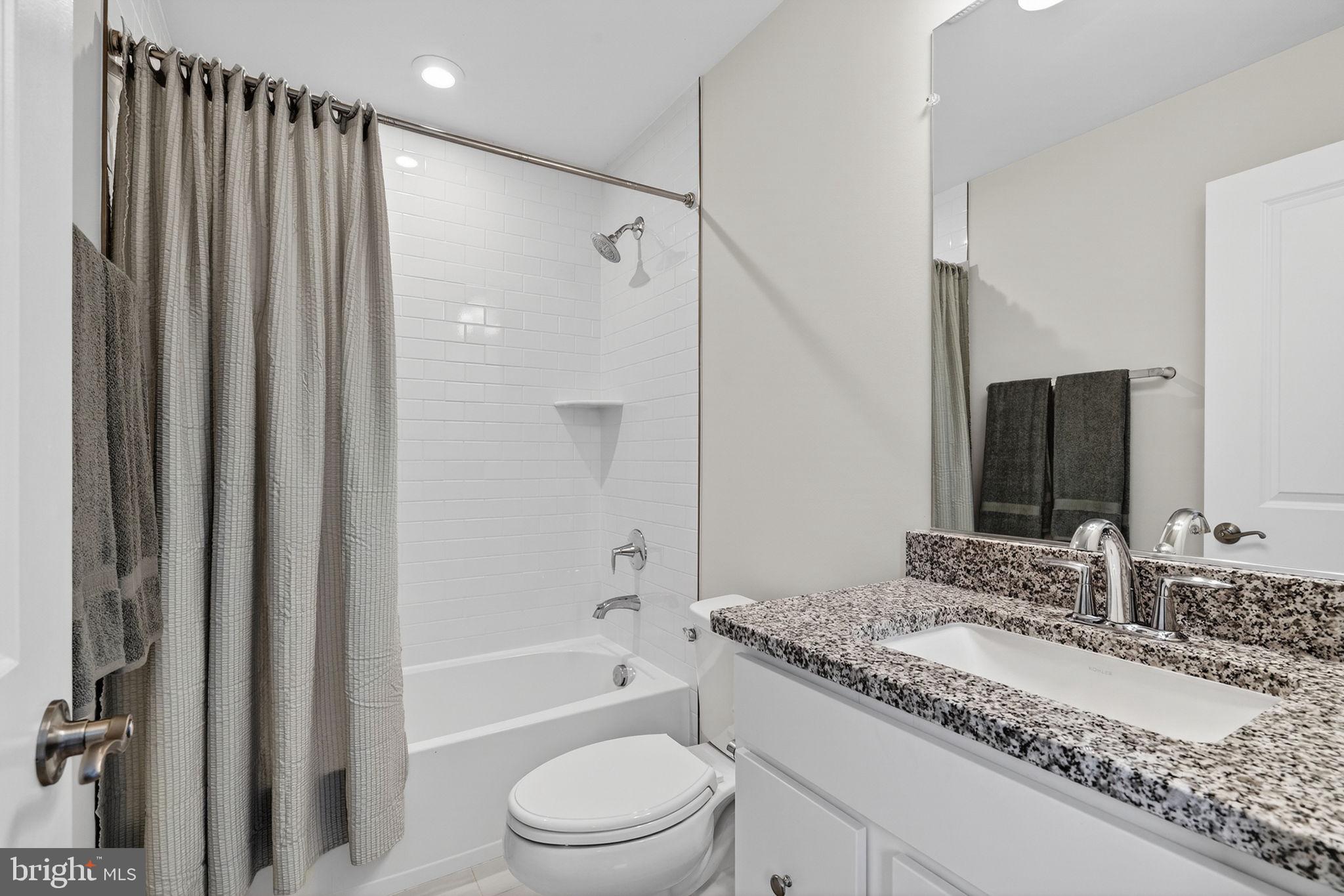 18245 Moss Garden Road Dumfries, VA 22026 - Photo 31 of 71 a bathroom with a granite countertop bathtub shower sink vanity and toilet