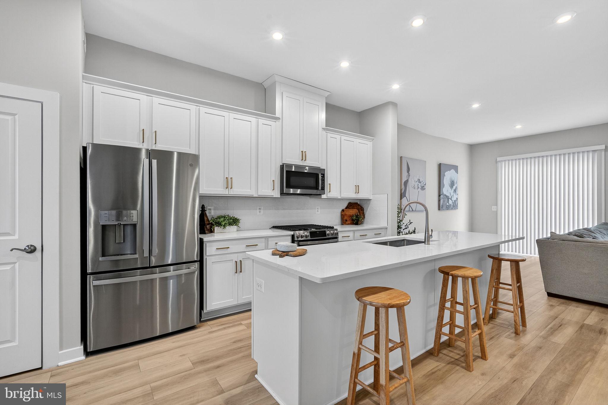 18245 Moss Garden Road Dumfries, VA 22026 - Photo 7 of 71 a kitchen with stainless steel appliances granite countertop a refrigerator a stove a sink a dining table and chairs