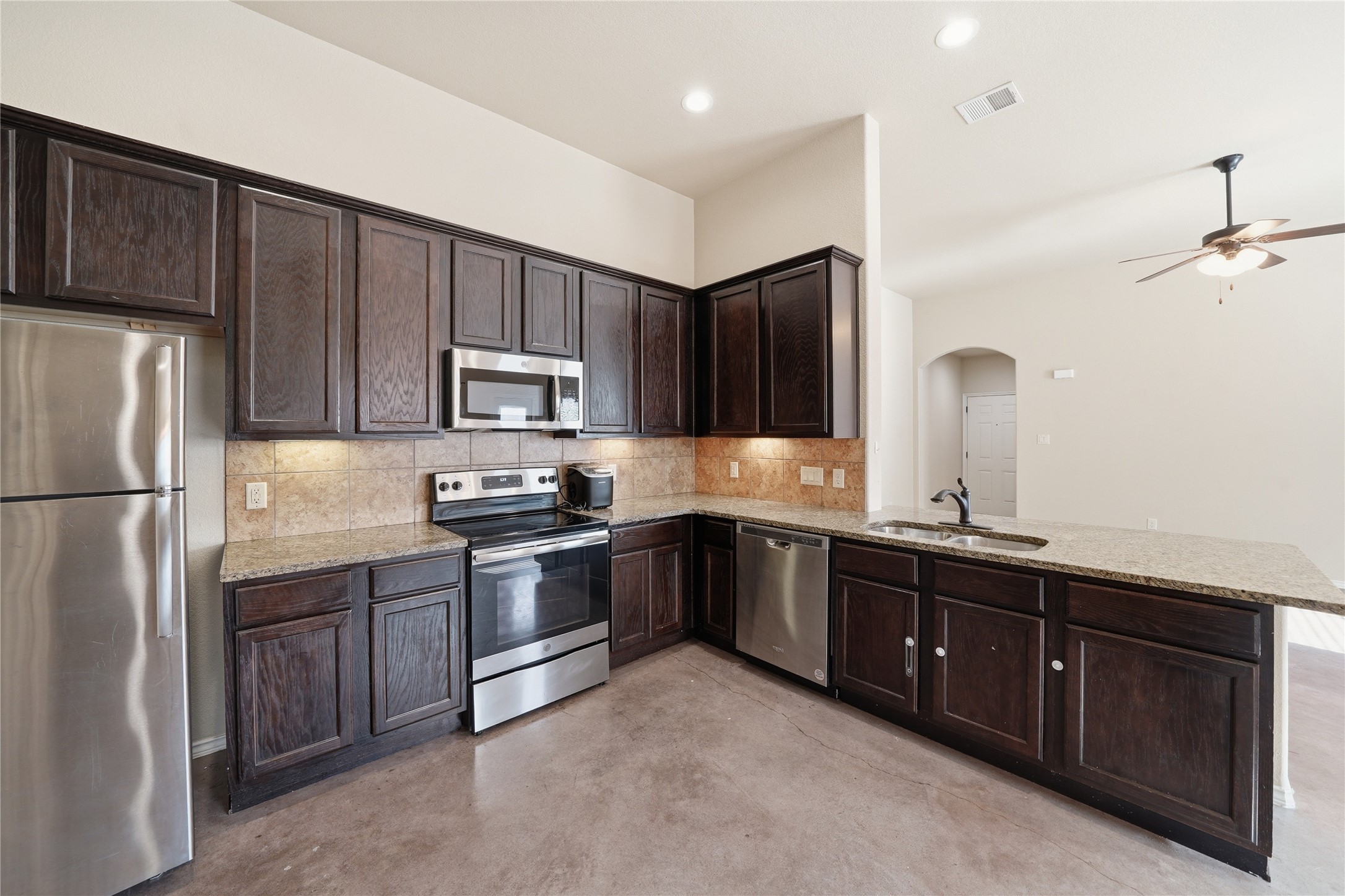 533 Jack Rabbit Lane, Unit A Buda, TX 78610 - Photo 3 of 34 A well-appointed kitchen features dark cabinetry, granite countertops, and modern stainless steel appliances.