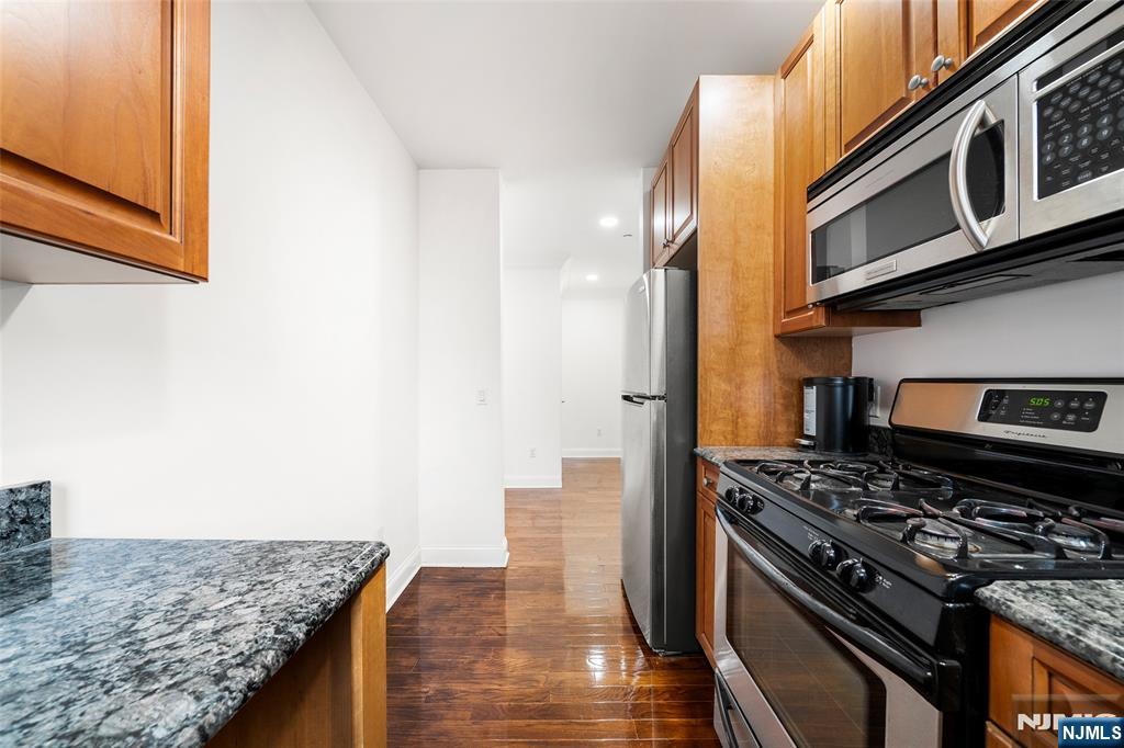 180 Edgewater Road, Unit 1A Cliffside Park, NJ 07010 - Photo 14 of 30 a kitchen with stainless steel appliances granite countertop a stove and a microwave