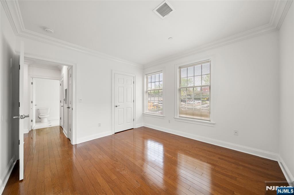180 Edgewater Road, Unit 1A Cliffside Park, NJ 07010 - Photo 17 of 30 an empty room with wooden floor and windows
