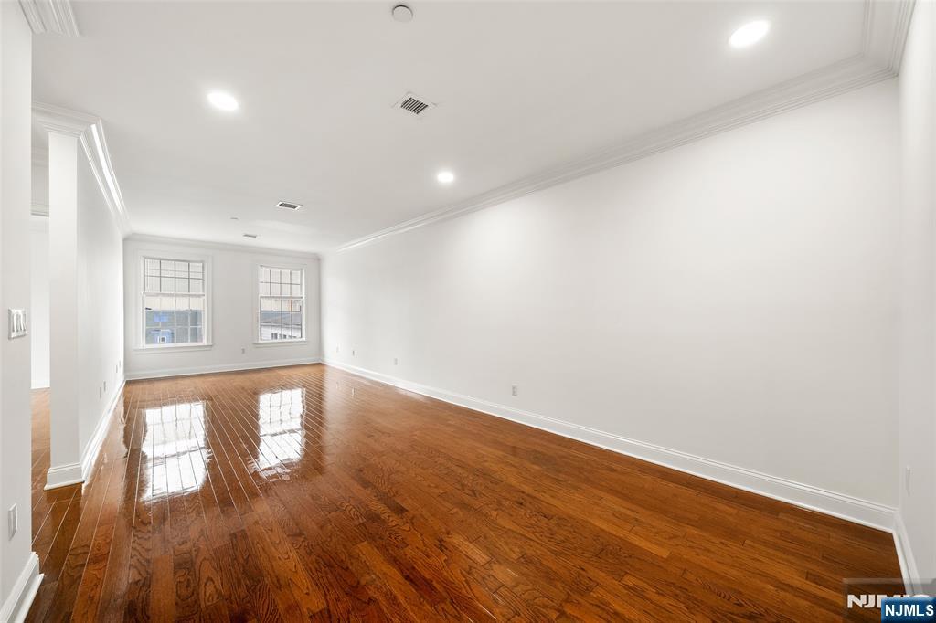 180 Edgewater Road, Unit 1A Cliffside Park, NJ 07010 - Photo 9 of 30 a view of empty room with wooden floor and fan