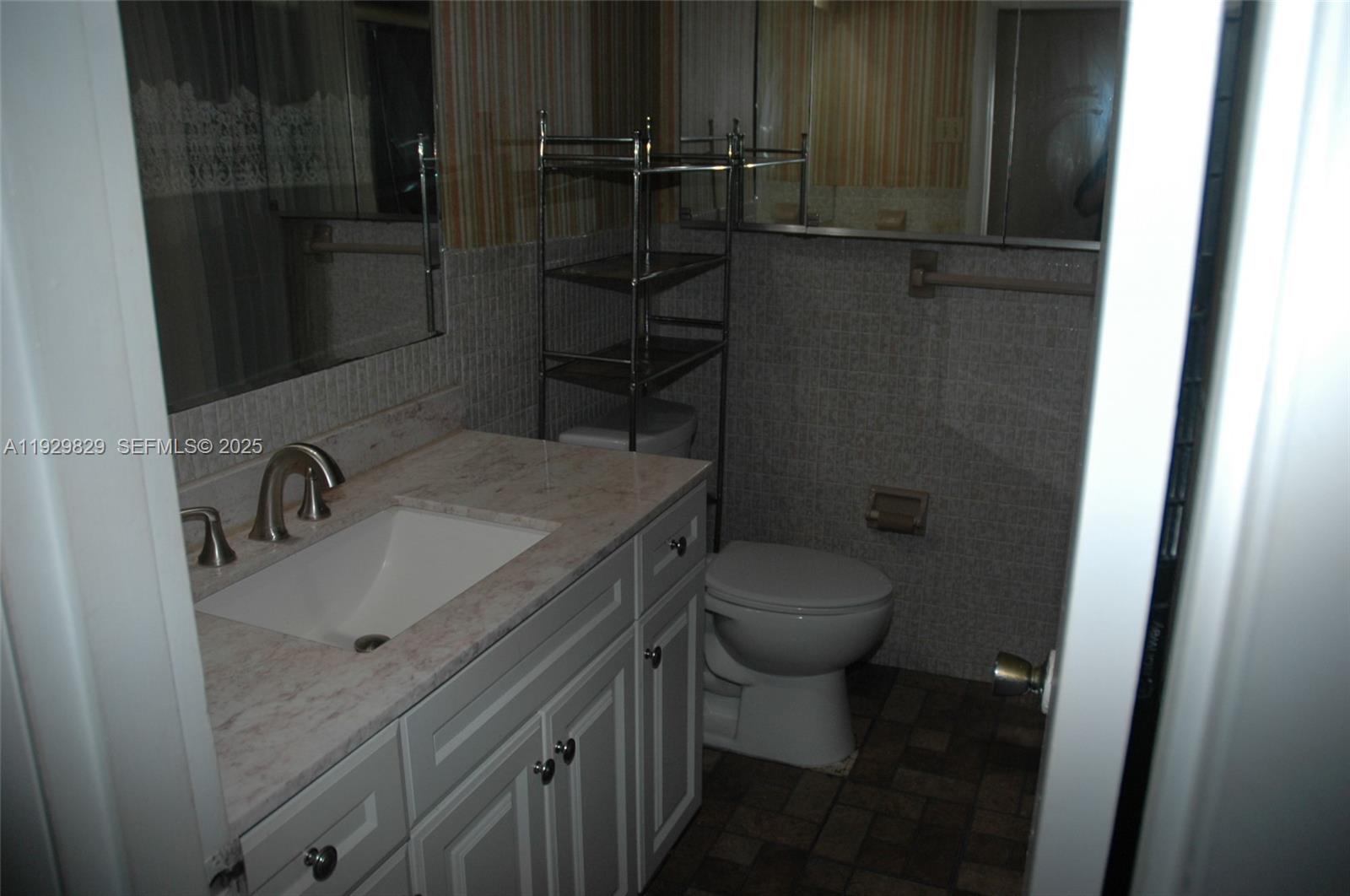5300 Washington Street, Unit F119 Hollywood, FL 33021 - Photo 16 of 24 a bathroom with a granite countertop sink toilet and shower