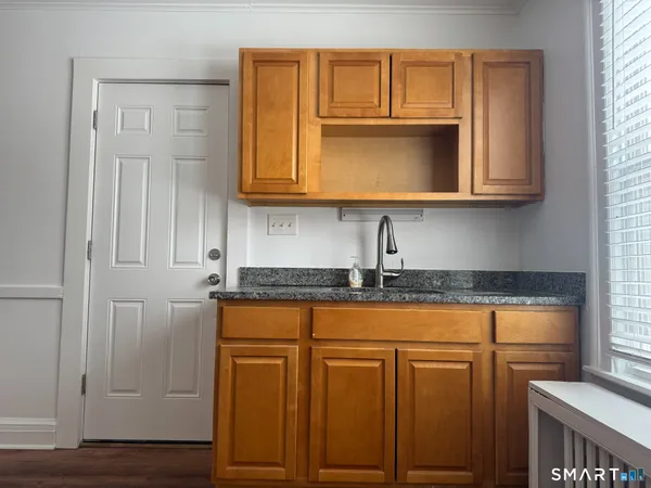 a kitchen with granite countertop cabinets stainless steel appliances and a window
