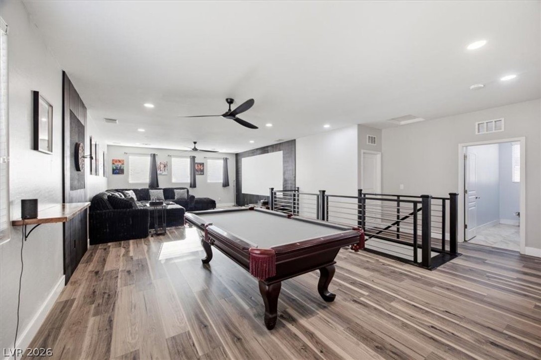 11009 Prairie Grove Road Las Vegas, NV 89179 - Photo 32 of 49 A vibrant recreation room features rich wood flooring, ample space for entertaining, and a convenient overlook to lower levels.