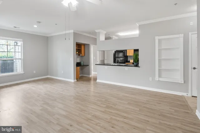 an empty room with wooden floor and window