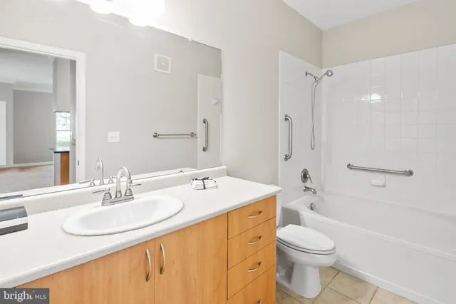 a bathroom with a granite countertop sink toilet a mirror and shower