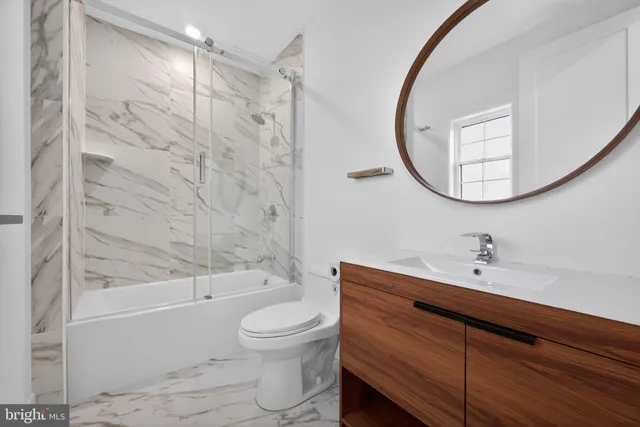 a bathroom with a sink a toilet and a mirror