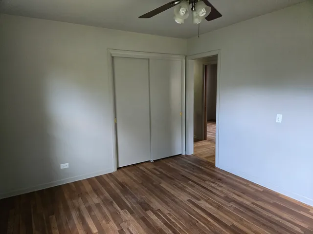 a view of a room with wooden floor and ceiling fan