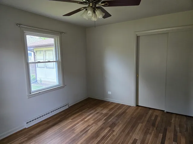 an empty room with a window and wooden floor