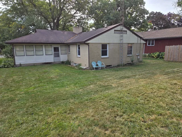 a view of a yard in front of a house with large tree