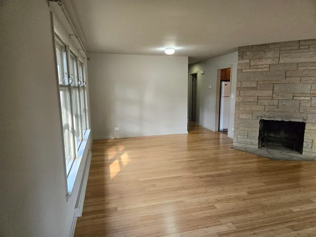 an empty room with wooden floor and a fireplace