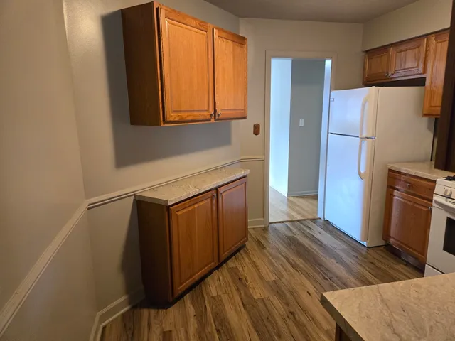 a kitchen with a refrigerator and a stove top oven