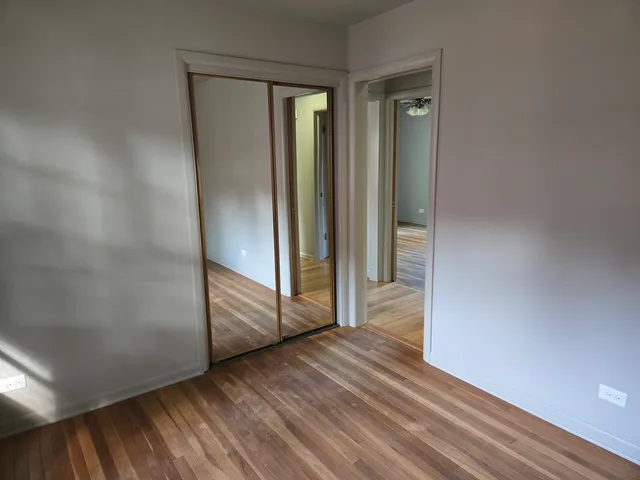 an empty room with wooden floor and entrance