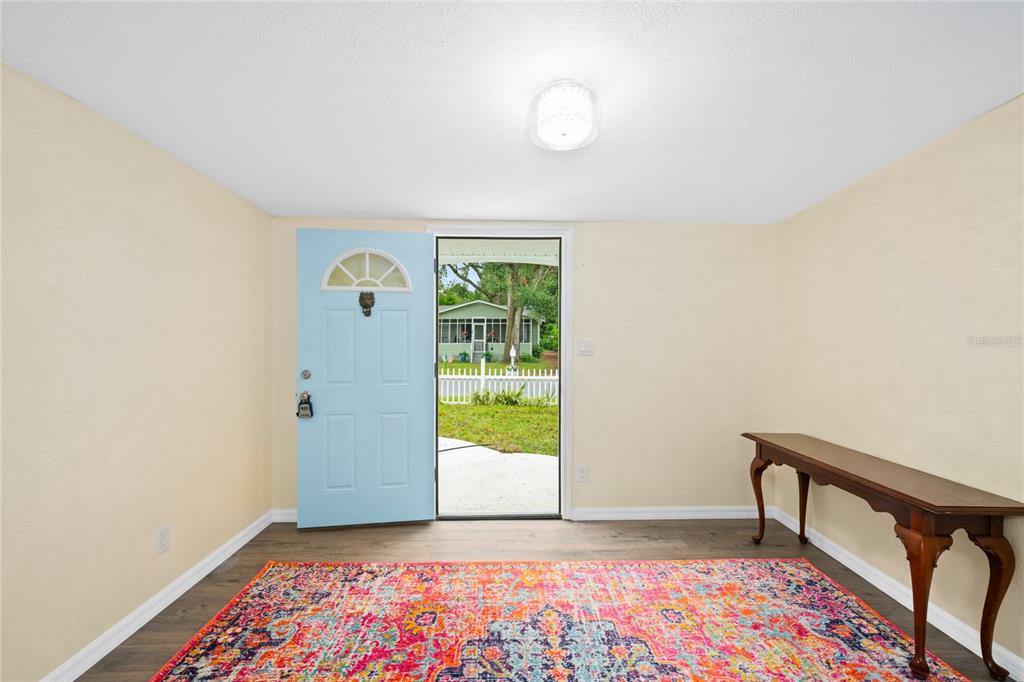 245 South Rhodes Street Mount Dora, FL 32757 - Photo 6 of 38 a view of an empty room with a window and a kitchen