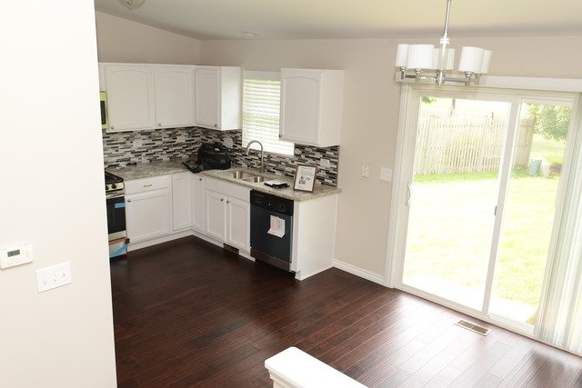 528 Wynbrooke Road Romeoville, IL 60446 - Photo 4 of 25 a kitchen with stainless steel appliances a stove a sink and white cabinets with wooden floor