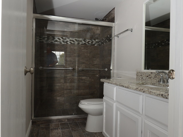 528 Wynbrooke Road Romeoville, IL 60446 - Photo 10 of 25 a bathroom with a granite countertop toilet a sink and a shower