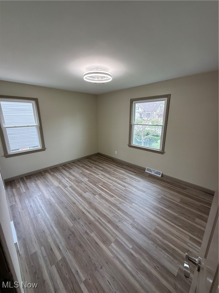 9417 Alexander Road Garfield Heights, OH 44125 - Photo 22 of 38 Unfurnished room with wood finished floors, baseboards, and visible vents