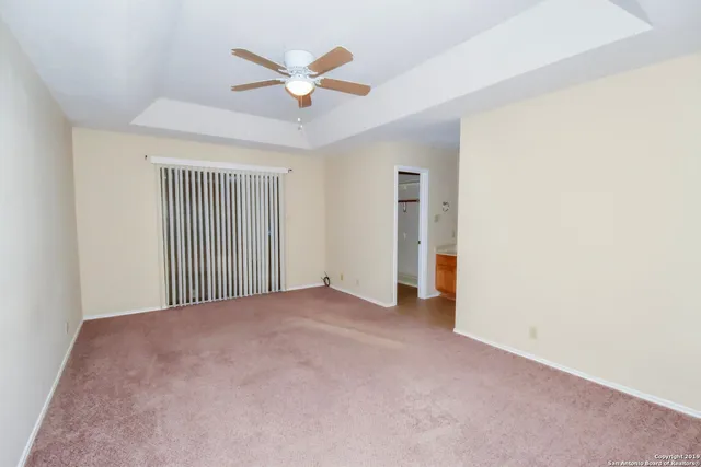 an empty room with a ceiling fan and a window