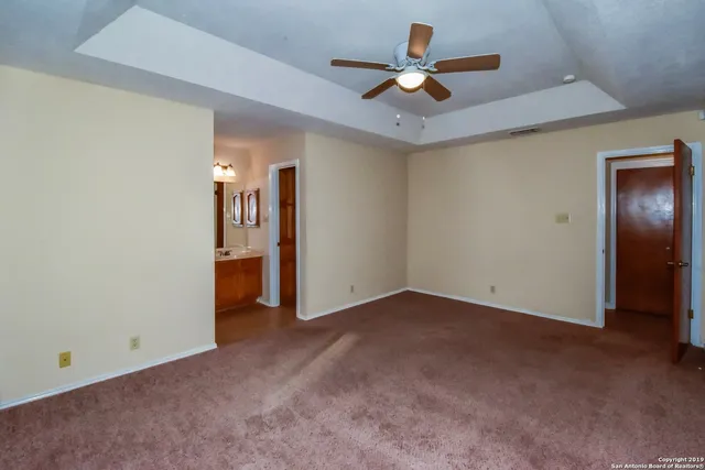 an empty room with closet and a ceiling fan