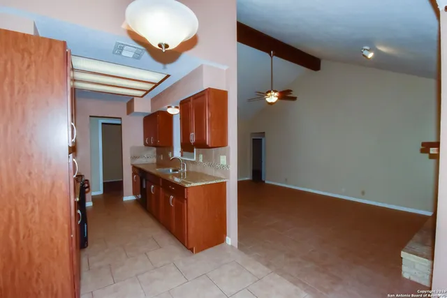 a kitchen with stainless steel appliances granite countertop a sink and a refrigerator