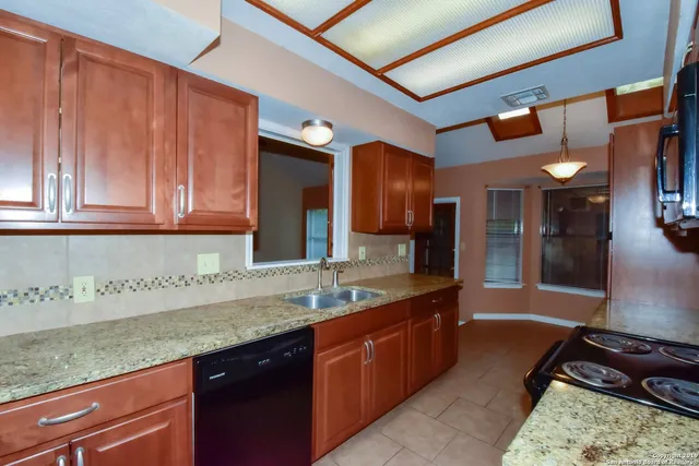 a kitchen with granite countertop a sink and cabinets