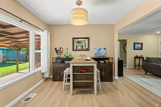 a living room with furniture kitchen view and a wooden floor
