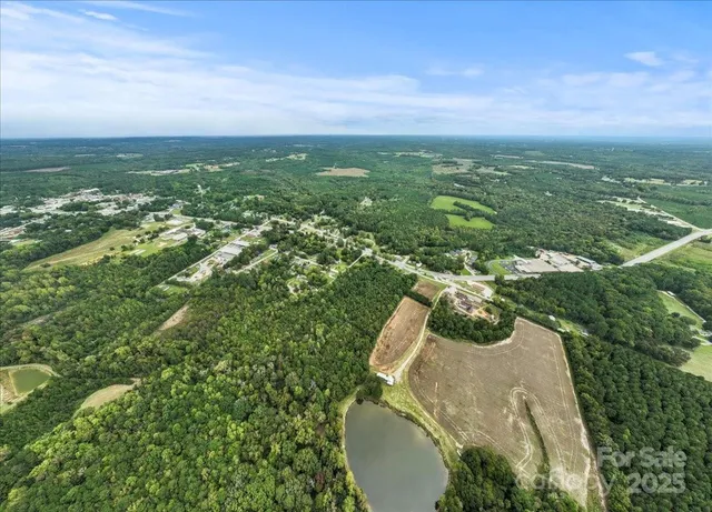 an aerial view of residential houses with outdoor space and trees