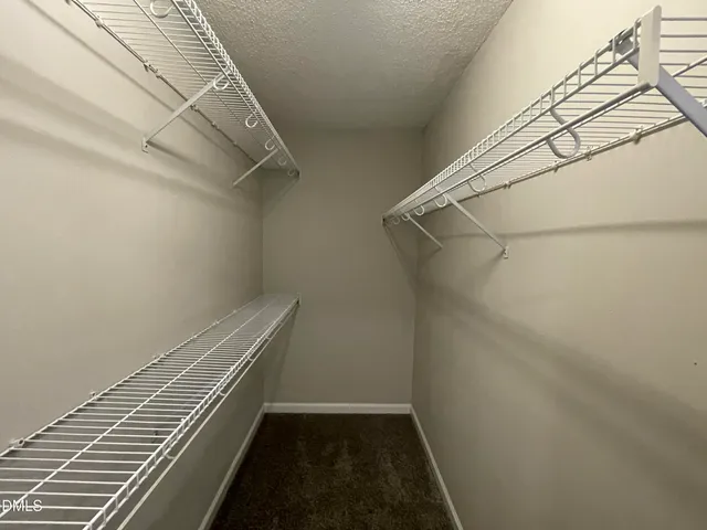 an empty room with wooden floor fireplace and windows