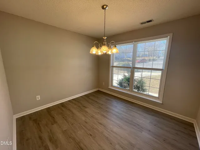 a view of a room with wooden floor and chandelier