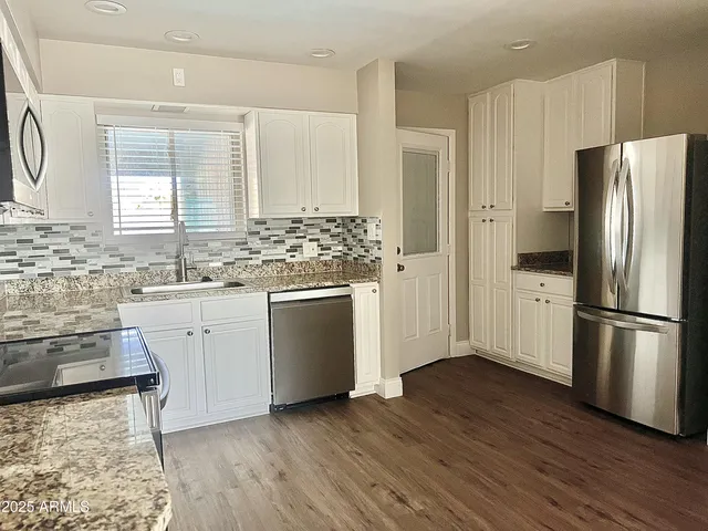 a kitchen with stainless steel appliances granite countertop a stove microwave and cabinets