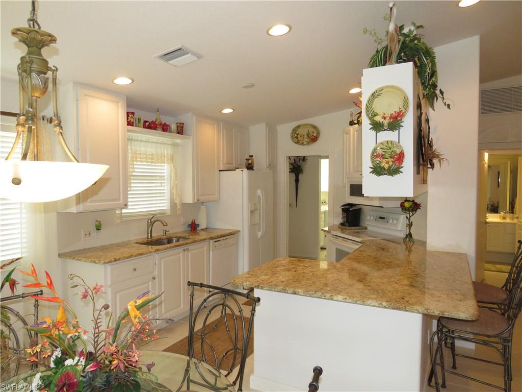 3732 Exuma Way Naples, FL 34119 - Photo 6 of 24 a kitchen with stainless steel appliances granite countertop a sink and cabinets