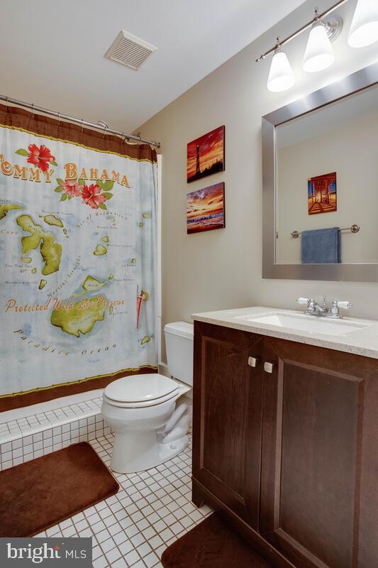 3369 Evans Road Huntingtown, MD 20639 - Photo 50 of 59 a bathroom with a sink a toilet and painting on the wall