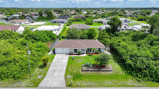 an aerial view of a house with a yard and lake view