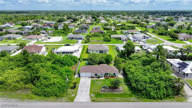 an aerial view of residential houses with outdoor space and trees