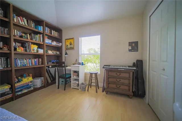 a view of a workspace with furniture and a bookshelf