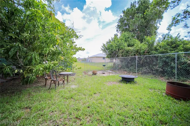 a backyard of a house with table and chairs