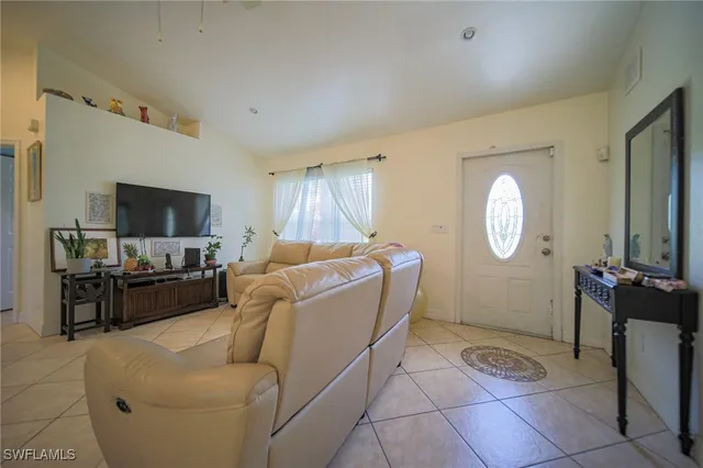 a living room with furniture a flat screen tv and a window