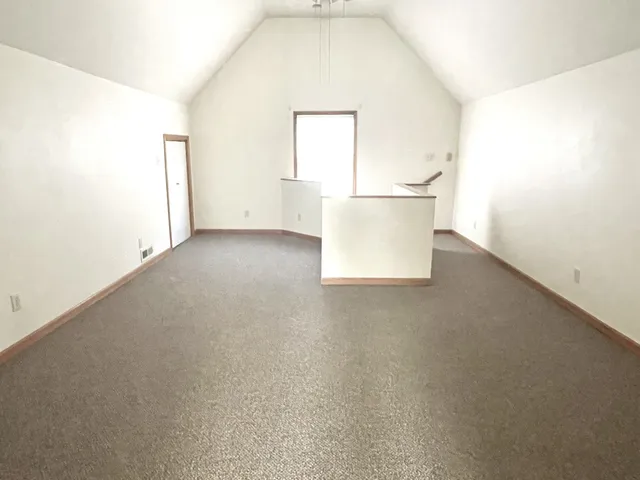 an empty room with wooden cabinet and mirror