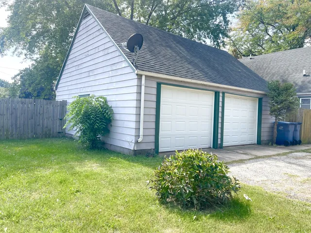 a view of a backyard with plants and large tree