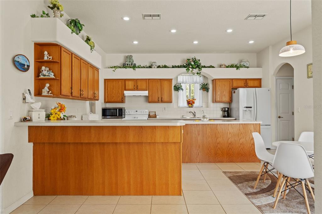 11405 Warm Wind Way Weeki Wachee, FL 34613 - Photo 18 of 46 a kitchen with stainless steel appliances kitchen island granite countertop a sink and cabinets