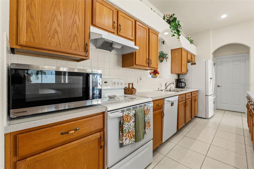 11405 Warm Wind Way Weeki Wachee, FL 34613 - Photo 22 of 46 a kitchen with stainless steel appliances kitchen island granite countertop a sink and cabinets